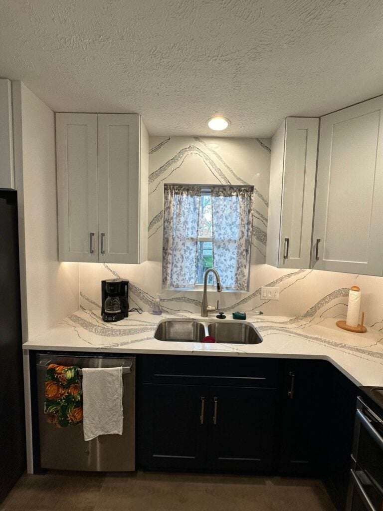 Kitchen remodel with full-height quartz backsplash and under-cabinet lighting